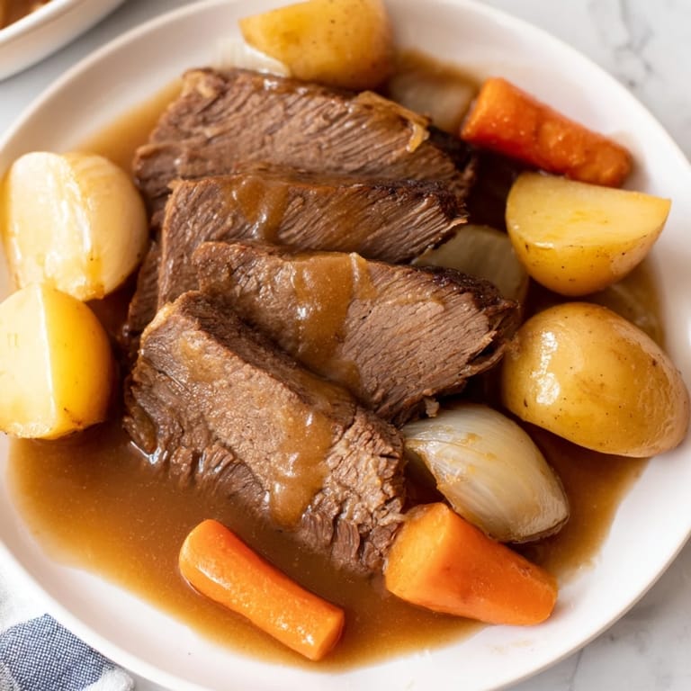 Hearty beef pot roast: fork-tender beef and vegetables in a deeply flavored gravy ready to be served.