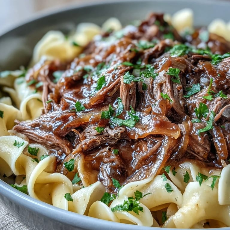 Shreddy beef and savory onion gravy transform buttered noodles in this comforting Crockpot French Onion Pot Roast Pasta dinner.