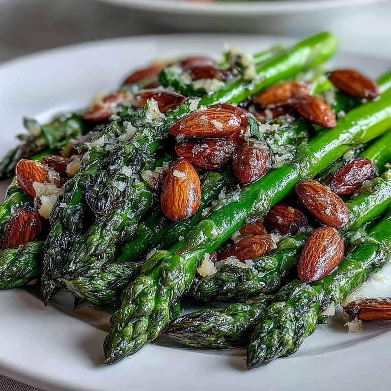 Crisp asparagus spears sautéed in lemon butter, topped with golden toasted almonds for a bright spring side.  