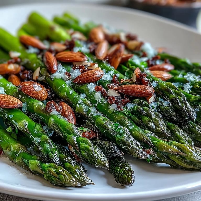 Asparagus with lemon butter sauce and toasted almonds, a flavorful vegetarian dish perfect for Easter or brunch.