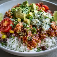 Salsa Chicken Bowls with shredded chicken in zesty salsa, served over rice with black beans and fresh toppings.  